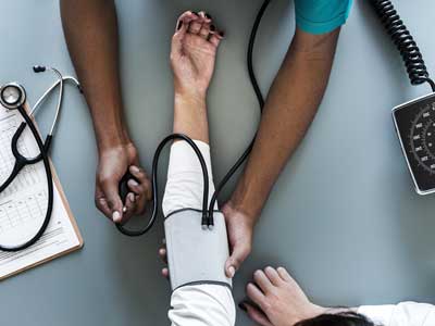 Doctor taking blood pressure of a patient